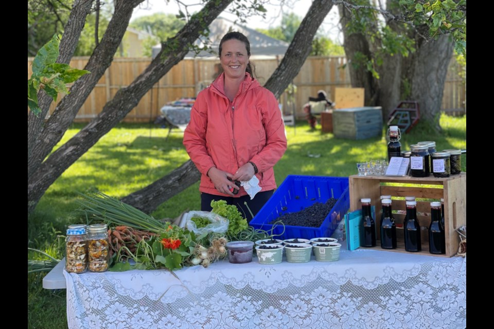 Tara Hamilton of La Belle Vie Farm in St. Charles stands at the market stand on the roadway showcasing haskap berries, along with haskap syrups and jams and other items grown at the farm. They also have a small hay production on site each year.