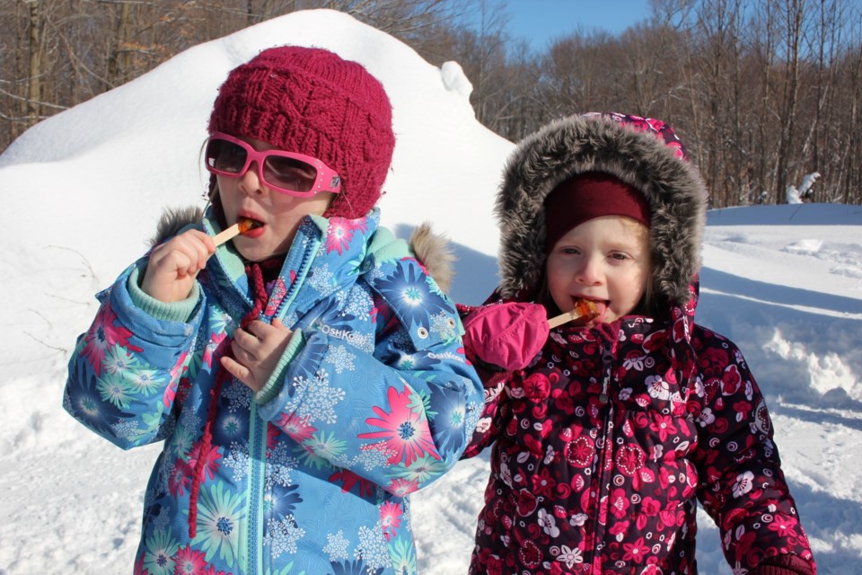 Ariel and Emilie Pelletier enjoyed some maple taffy at Maple Hill Farm March 26.