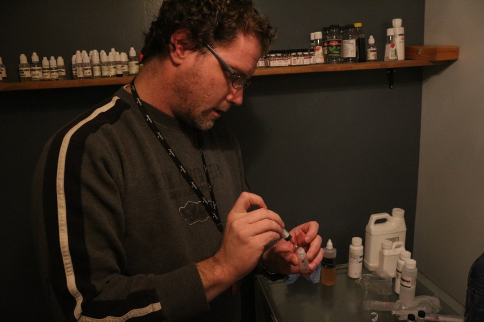 Greg Steele mixes up a small batch of e-juice inside Crystal Fog Vapes. Steele is one of the very few people in Sudbury who custom makes e-juice right on site at his shop. Photo: Matt Durnan.