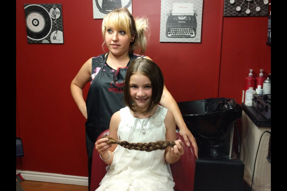 Nine-year-old Evangelina Bovay-Larose had 14 inches of her hair chopped off by Courtney Cuts owner Courtney Basso on July 26 to donate to Angel Hair for Kids. Photo: Jonathan Migneault