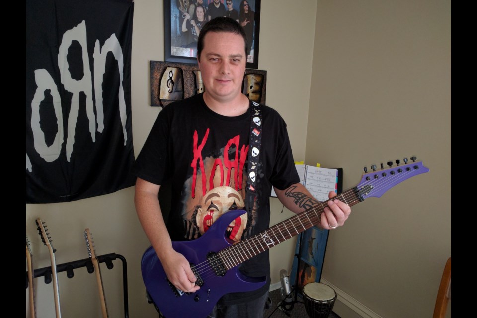 Andrew May painted one of his guitars purple to promote National Epilepsy Month in November (purple is the official colour for epilepsy awareness). May said there are no support groups in Sudbury for people with epilepsy. Photo by Jonathan Migneault.