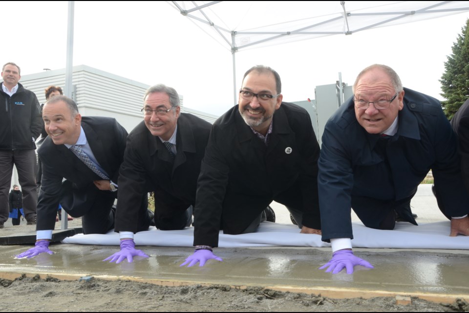 While the Smart Microgrid is designed to lessen Science North's footprint on the environment, guest, from left, Coun. Mark Signoretti, Keyvan Cohanim, Chief Commercial Officer of Opus One Solutions, Sudbury MPP and Minister of Energy Glenn Thibeault and Greater Sudbury Mayor Brian Bigger, left their handprints on the project. Photo by Arron Pickard.