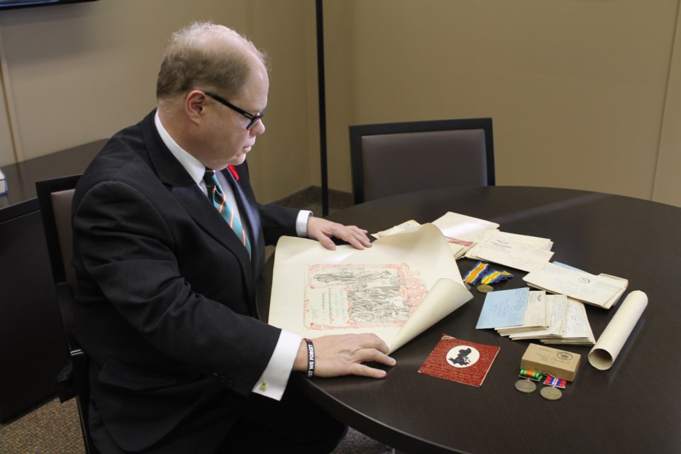 Kevin McCormick, President and Vice-Chancellor of Huntington University looks over some artifacts that will soon be repatriating through Project Honour and Preserve. Supplied photo.