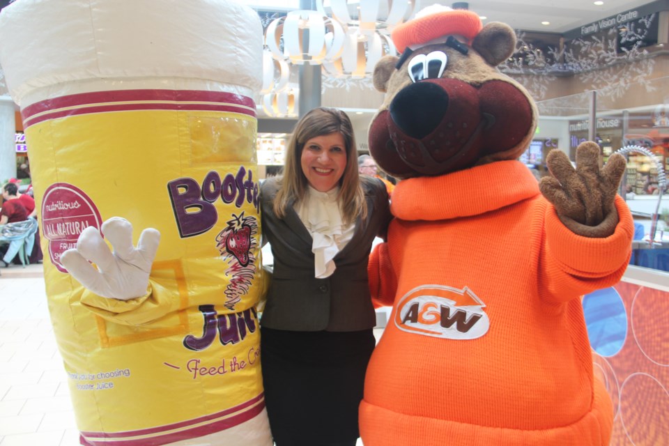 New Sudbury Centre general manager Jenny Beckerton poses with Cuppy (the mascot for Booster Juice) and the A&W Root Bear at a Feb. 28 celebration of the completion of renovations to the mall's food court. Photo by Heidi Ulrichsen.