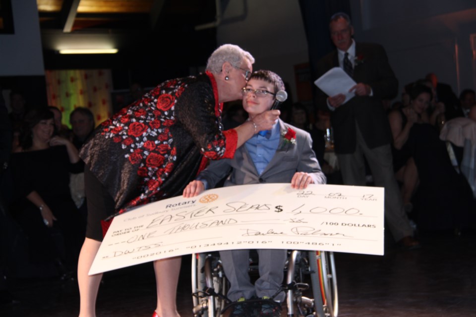 Darlene Palmer from Sudbury Rotary Sunrisers plants a kiss on Kaeden Dennie after presenting him with a cheque for $1,000. Photo: Matt Durnan