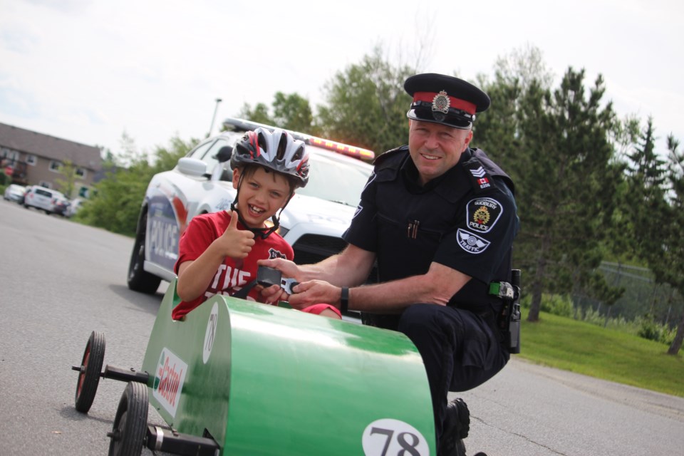 Landon Pamser, 8, is excited to enter this year's Soap Box Derby which takes place in Hanmer on June 17. Landon is pictured here with Greater Sudbury Police Service Sgt. Steve Russell. (Heather Green-Oliver/Sudbury.com)