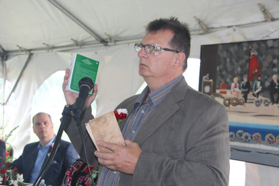 Dave Stewart, health and safety co-chair at Nickel Rim South, shows off the Ontario mining safety regulations from 1919, and the modern regulations during the Workers' Memorial Day ceremony June 20. (Heidi Ulrichsen/Sudbury.com) 