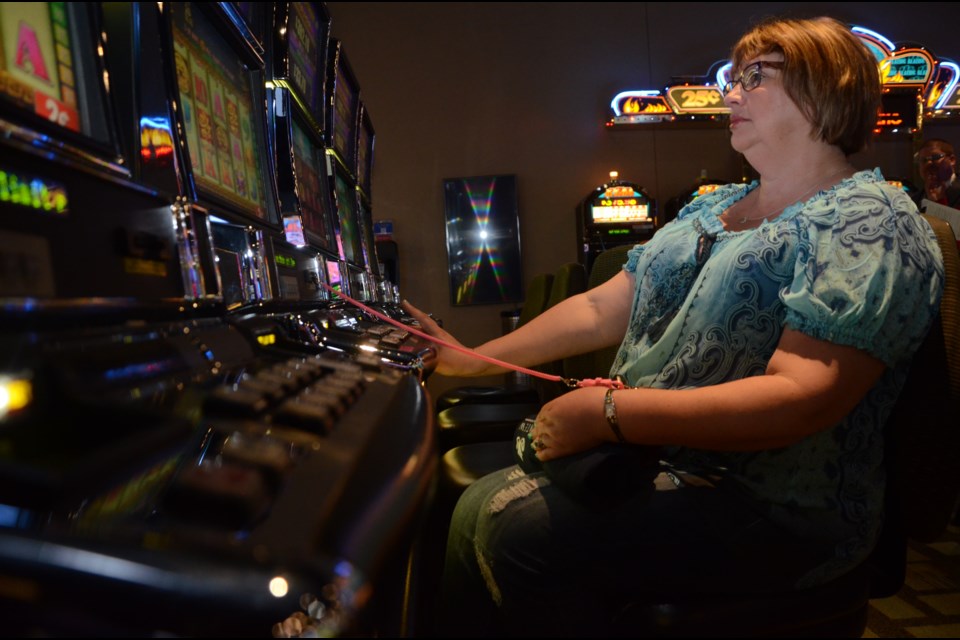JaneMarie Broderick tries her luck at a slot machine during the customer celebration day at Gateway Casinos. (Arron Pickard/Sudbury.com)
