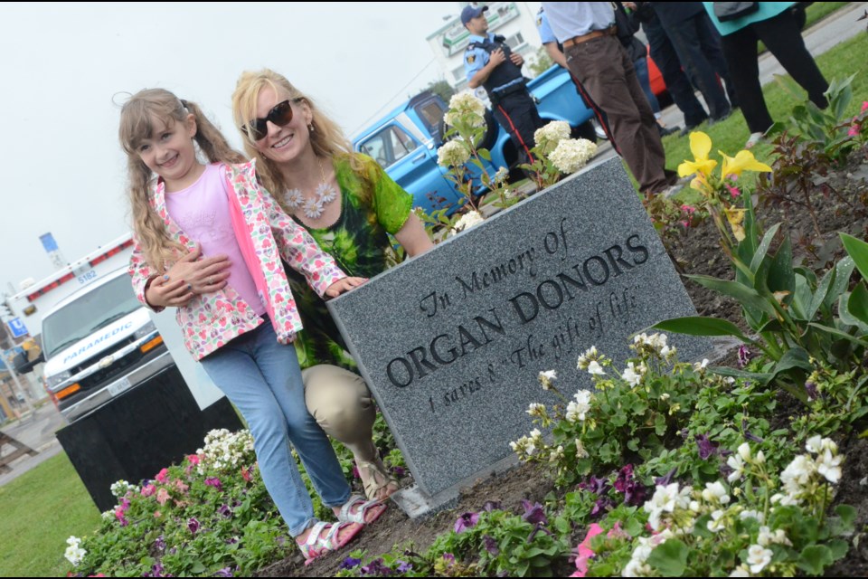 Nancy Griffin and her daughter, Zoe, pose with the stone monument erected at what will eventually be named Memory Park on Lorne Street. The monument bears the name of Nancy's late husband, Rich Griffin, who as an organ donor and saved the lives of five people as a result. (Arron Pickard/Sudbury.com)