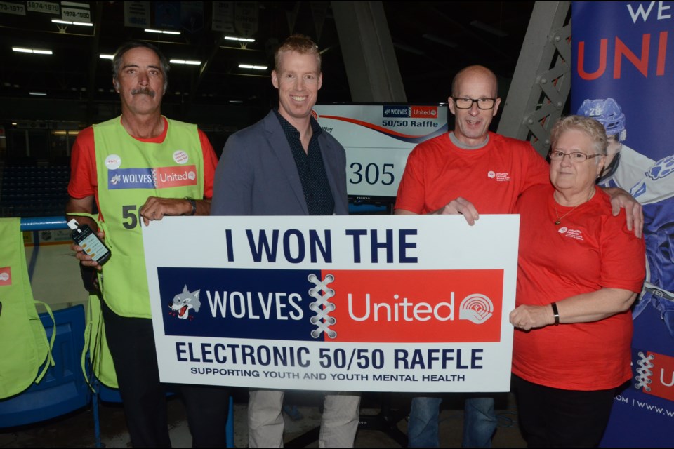 United Way Sudbury and Nipissing District volunteers Chris Peters, left, and Sylvie Prevost, right, helped launch Wolves United's new 50/50 draw initiative with Wolves vice-president of marketing Andrew Dale and United Way executive director Michael Cullen. (Arron Pickard/Sudbury.com)
