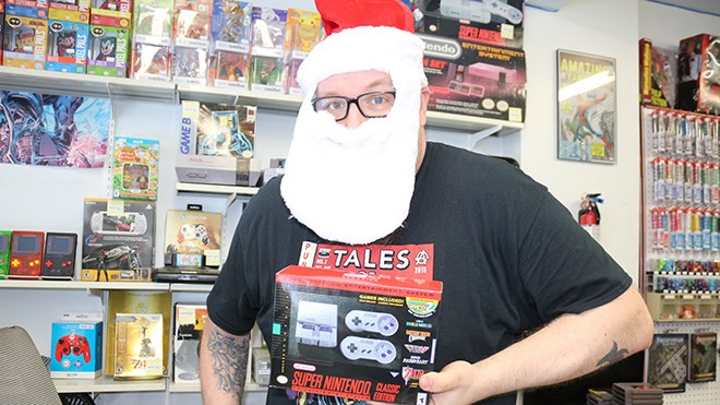 Comics North owner Cal Abram (a.k.a Festive Man) shows off the SNES Mini that will be raffled off at the second Toy+Food Drive on Dec. 10. (Heather Green-Oliver)
