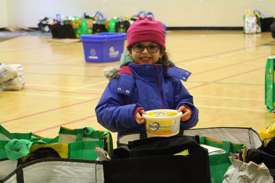Chloe Laverdiere, 5, helps pack food items for families in need  (Gia Patil)