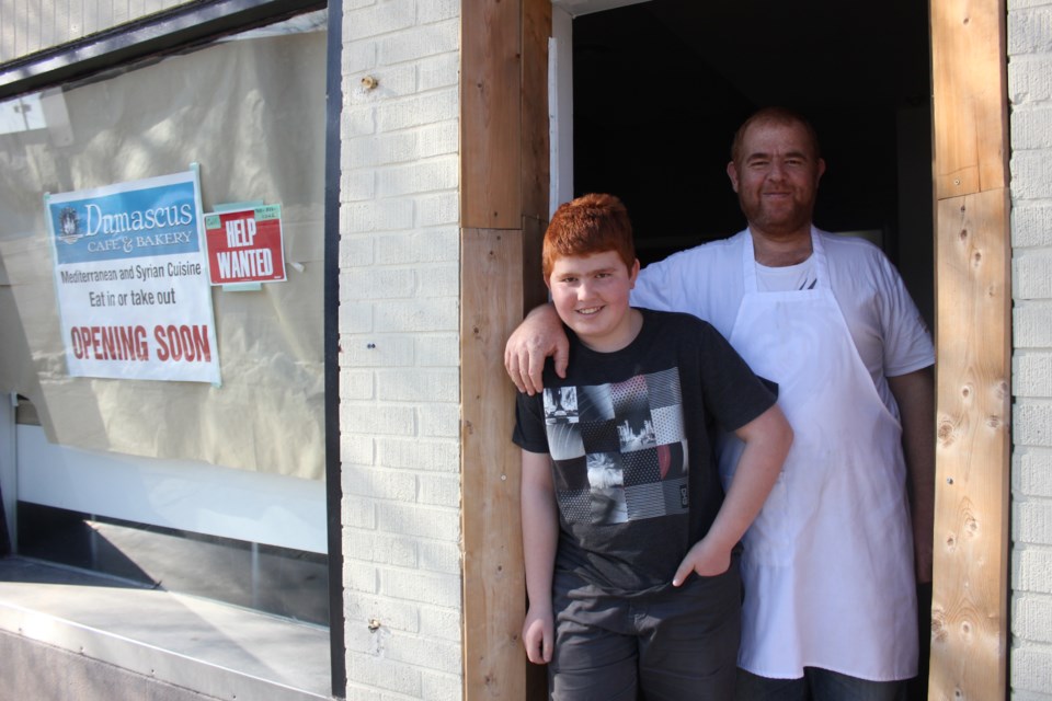 Hussein Qarquoz and one of his sons, Nabil, outside the door to the Damascus Café & Bakery on Beech Street in downtown Sudbury. (Ella Jane Myers/EllaJaneMyers.com)