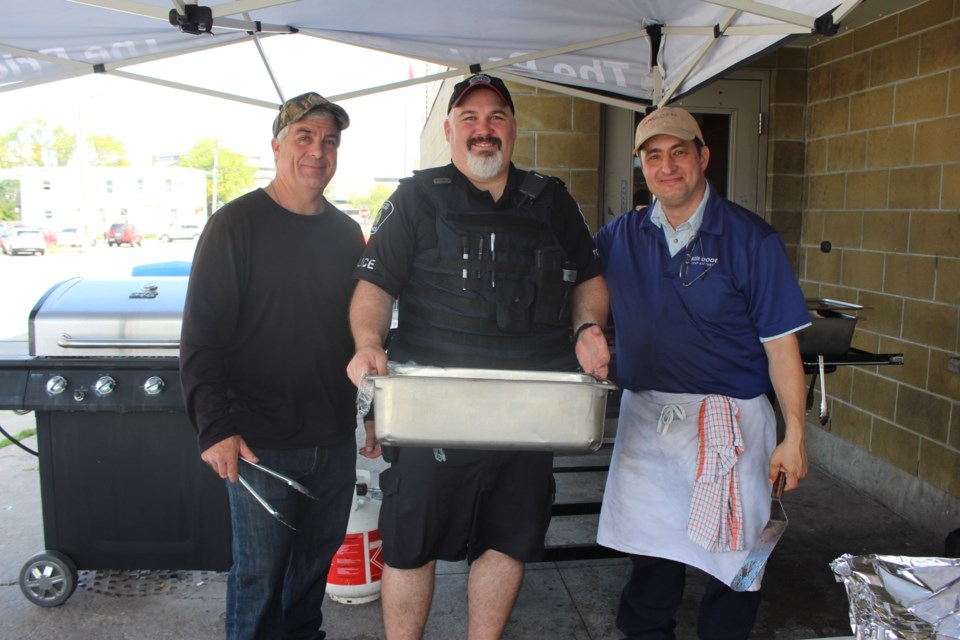 Blue Door soup kitchen volunteer Marc Fredette, GSPS Constable Matt Hall and Blue Door staff member Steve Robitaille were busy at the grill. 