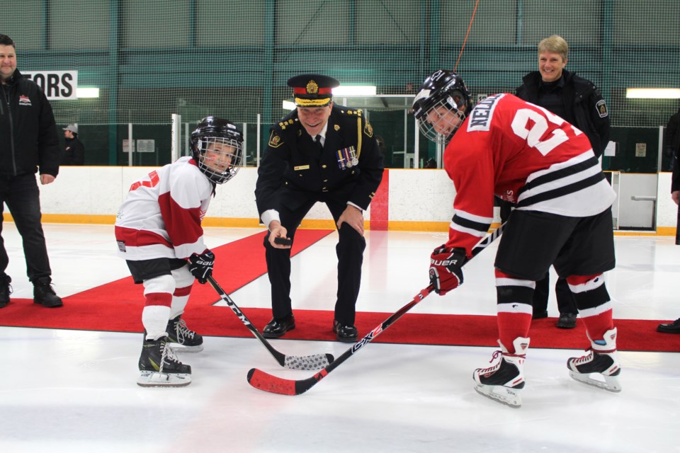 Greater Sudbury Police Services officially dropped the puck for the 10th anniversary of the Police Cup hockey tournament. Pictured left to right: Cedar Park Red Wings player Dane Nielson, Chief Paul Pedersen and Algonquin Hawks player Cohen Neldor. (Heather Green-Oliver/Sudbury.com)