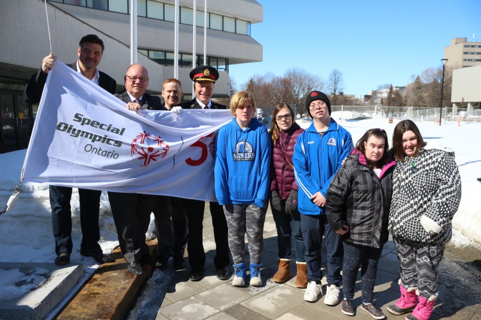 Helping to hoist the 50th anniversary Special Olympics Ontario flag at Tom Davies Square on Monday was, from left, Sudbury Wolves owner Dario Zulich, mayor Brian Bigger, Special Olympics Sudbury sports and competition developer Jarrod Copland, Greater Sudbury Police Chief Paul Pedersen and Special Olympics athletes Krystin Albert, Josée Seguin, Kole O'Malley, Danie Houle and Shannon O'Reilly. (Arron Pickard)