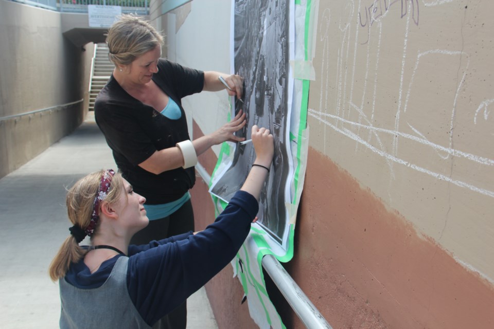 Monique Legault and assistant Lauren Carlson work on the mural. (Heidi Ulrichsen/Sudbury.com)