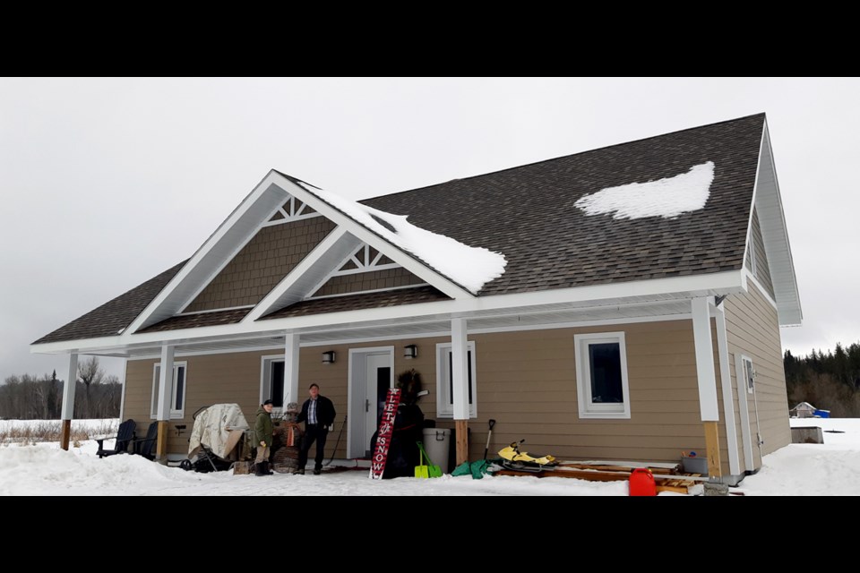 Bernard Proulx and his grandson Benoît stand outside the passive house Proulx built for his son in 2016. (Supplied)