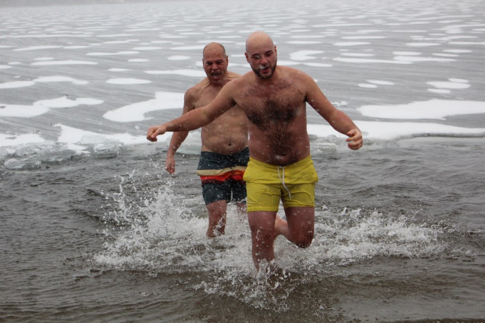 Jordan Cheff (front) was joined by Sudbury MPP Jamie West (background) and several others in jumping into the freezing waters of Lake Nepahwin just as a snowstorm hit Greater Sudbury Saturday morning. (Heidi Ulrichsen/Sudbury.com)
