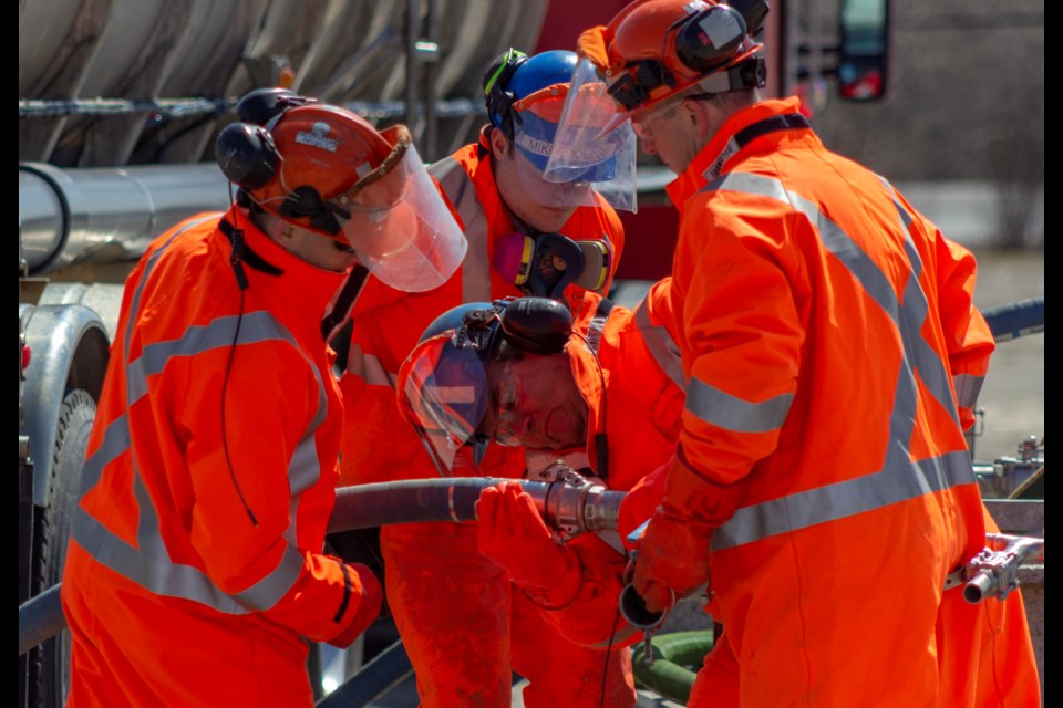 Glencore emergency response members attach hoses to demonstrate how the acid would be removed from the faulty truck and into a new truck.