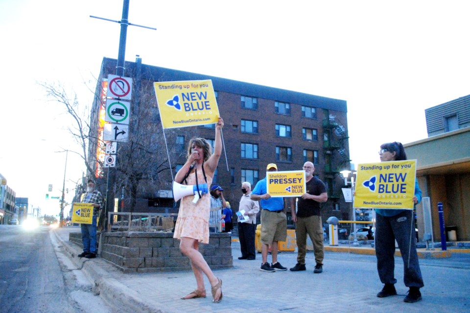 New Blue Party of Ontario supporters are seen protesting outside of the Greater Sudbury Chamber of Commerce offices on Thursday night in response to their candidates not being invited to participate in candidate debates. 