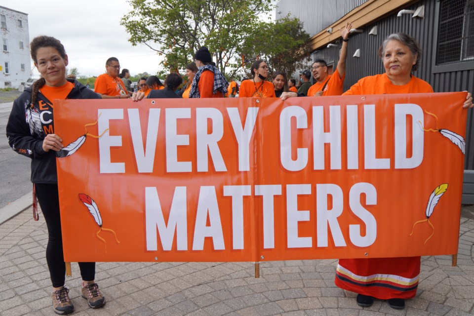A sign held at the beginning of the walk reads Every Child Matters                        