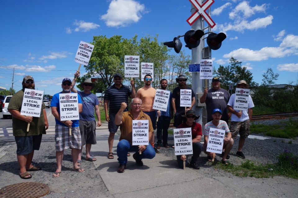 A dozen members of the IBEW Sudbury Local 2052 participated in strike action at a rail crossing along Barrydowne Road on June 23. 
                               