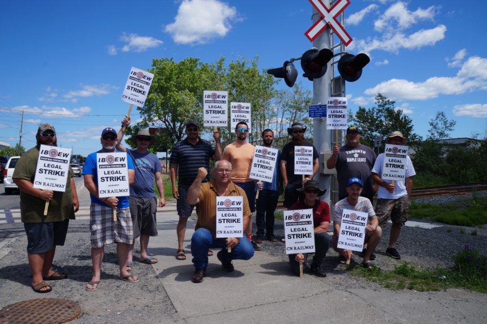 A dozen members of the IBEW Sudbury Local 2052 participated in strike action at a rail crossing along Barry Downe Road on June 23. 
                               