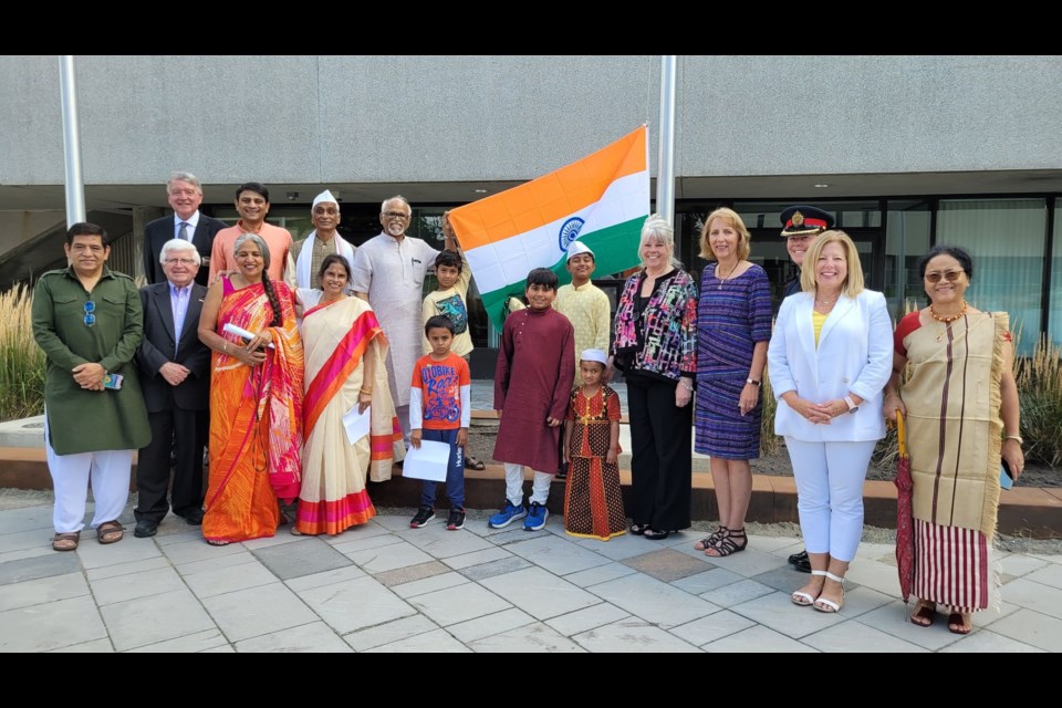 At hthe flag raising for India Independence Day celebrations, a group of dignitaries and community members gather to raise the flag. 