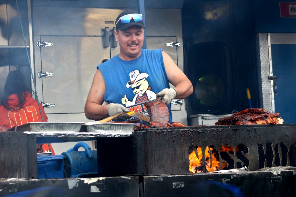 Boss Hog’s cook Cole Beadle works on ribs at Bell Park this afternoon as part of Ribfest. 