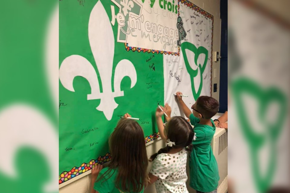Students at 'École Notre-Dame wrote names and messages on the flag in honour of Franco-Ontarian Day. (Supplied)