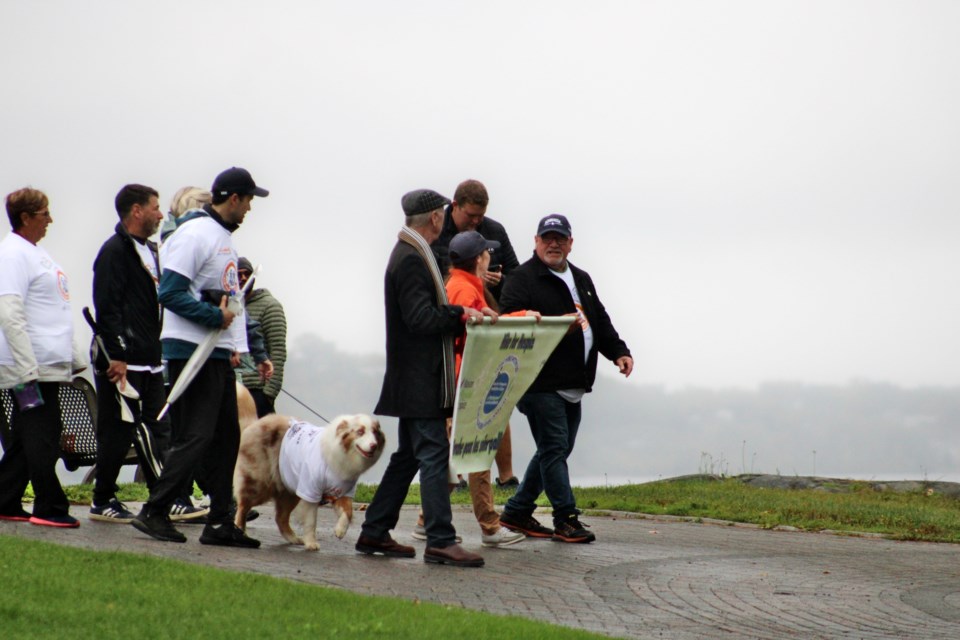 Participants in this afternoon’s Hike for Hospice event make their way down Bell Park. 