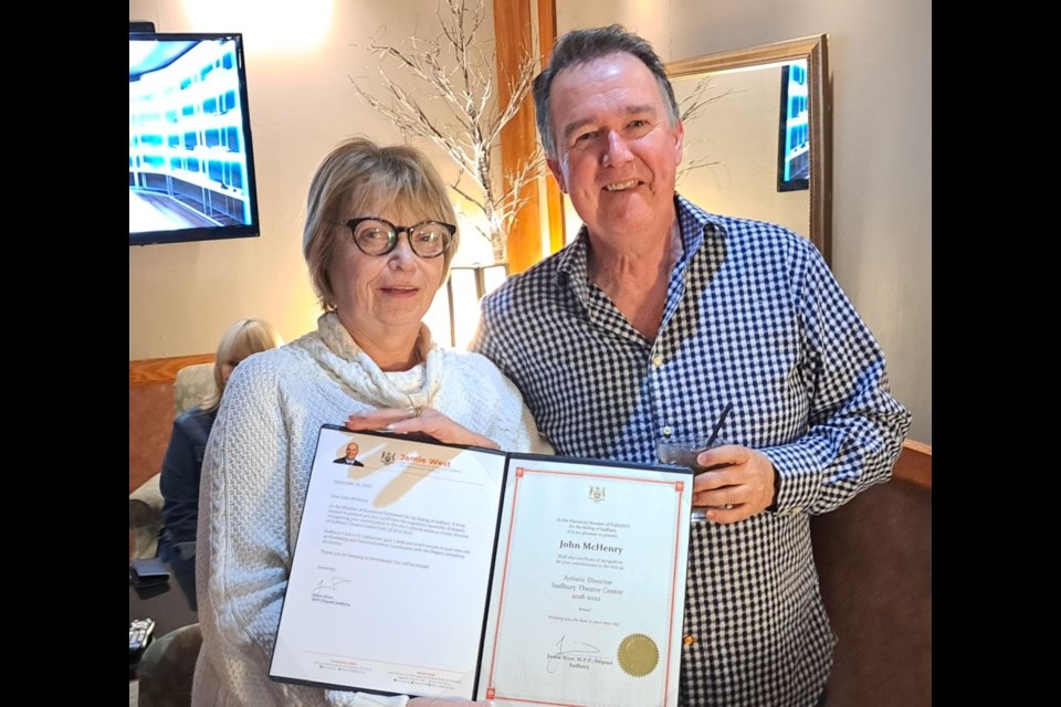 Vicki Gilhula of the Sudbury Arts Council presents John McHenry with a certificate of appreciation from Sudbury MPP Jamie West.