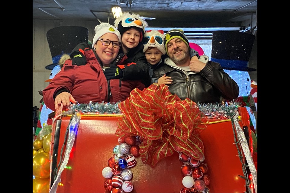Melanie and Sean McDonald and their two kids, Parker, 7, and Matteo, 5, on Santa’s float.