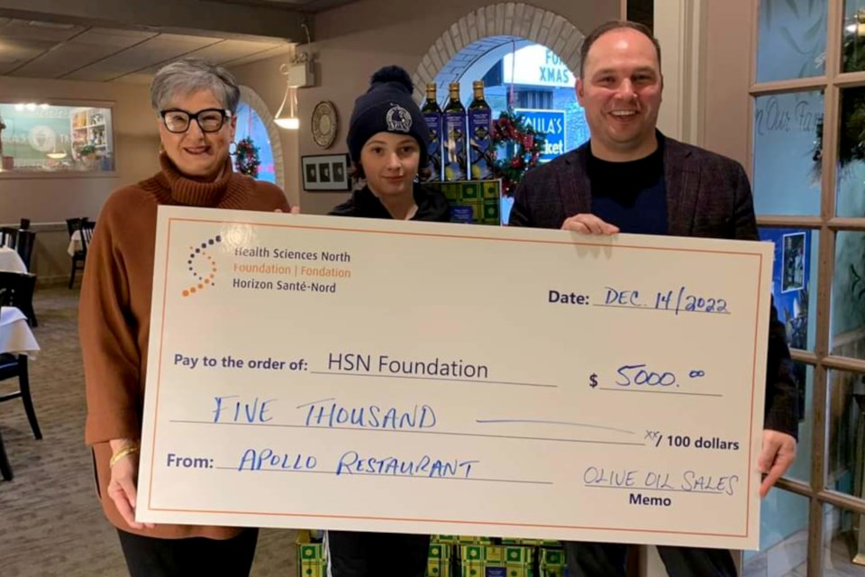 Apollo Restaurant owner Toula Sakellaris and her grandson, George (a.k.a. Van), present a cheque for $5,000 from olive oil sales to Anthony Keating, president and chief development officer with Health Sciences North Foundation, to support the foundation’s work on behalf of Sudbury’s hospital.
