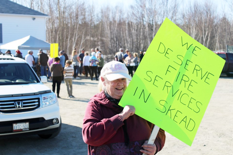 1 / 9 Skead resident Arlene Mann is seen with a sign in support of the Skead fire station during a public meeting in the community on Thursday evening.
