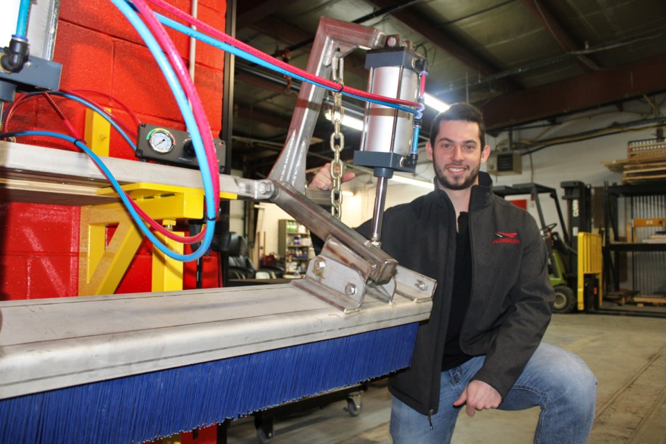 Plowbrush vice-president of operations Brennan Chaput is seen with one of the snow plow devices at their shop in Falconbridge.