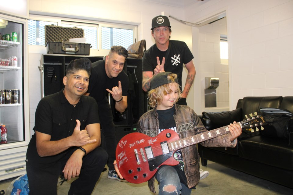 Members of the rock group Billy Talent pose for a photo with Sudbury superfan Avery Bazinet, whose guitar they signed. The group is seen backstage at the Grace Hartman Amphitheatre at Bell Park prior to their July 29 performance. From left is guitar player Ian D’Sa, bass player Jonathan Gallant and singer Benjamin Kowalewicz. 

