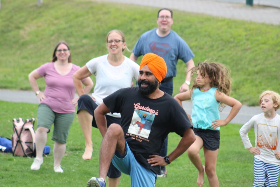 Positivity advocate Gurdeep Pandher instructs a group of approximately 30 people on Bhangra, the traditional dance of Punjab, at Bell Park on Sunday evening.
