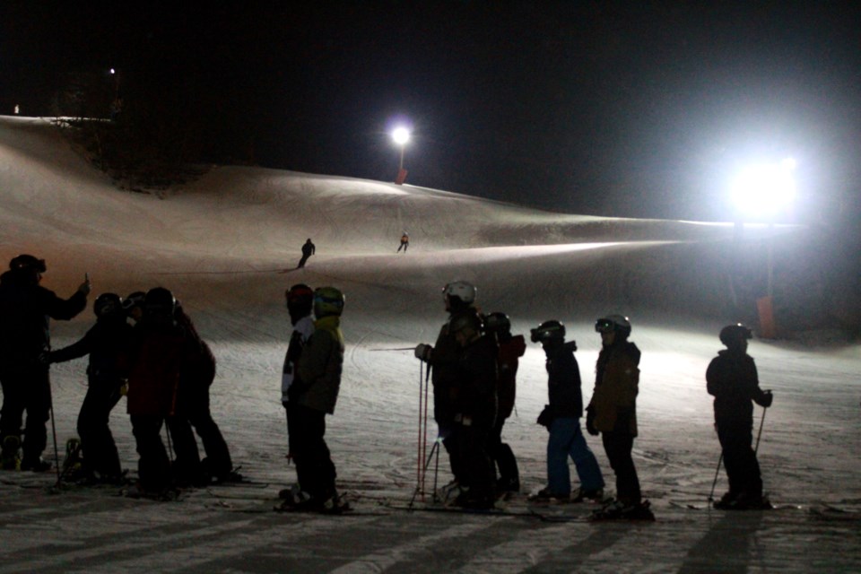 Outdoor enthusiasts line up for the lift at the Lively Ski Hill on Friday night.