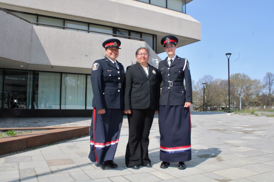 Ribbon skirt designer Robin Wemigwans is bookended by two Greater Sudbury Police Service members modelling the skirts. At left is Const. Katrina Pitawanakwat, and at right is Const. Anik Dennie. 
