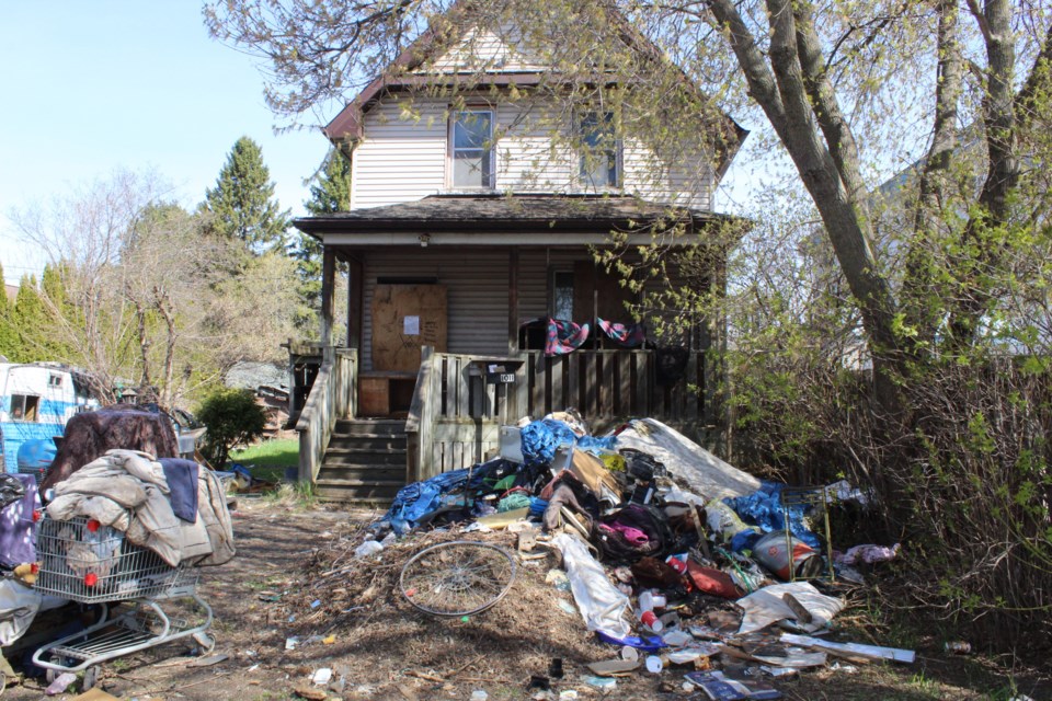 The house with a visible pile of trash in the yard the week before cleanup. (Penny Robinson)