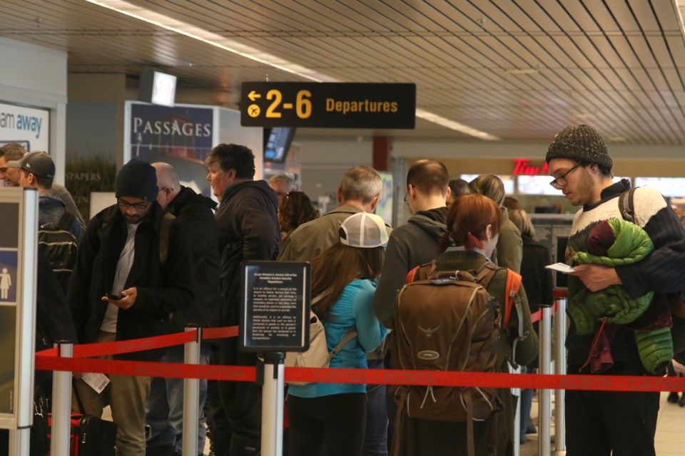 Travelers wait in line at the Thunder Bay Airport Wednesday afternoon. Luckily, there were no significantly long lines, but airport officials say December is their busiest on record. 
