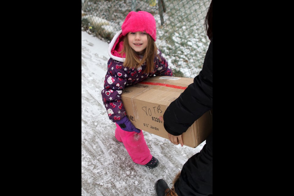 Sherbrooke Public School student Kendra Perkins helps bring a box of Christmas gifts donated by Helping Hands into the school gymnasium on Monday, Dec. 19, 2016 (Leith Dunick, tbnewswatch.com). 