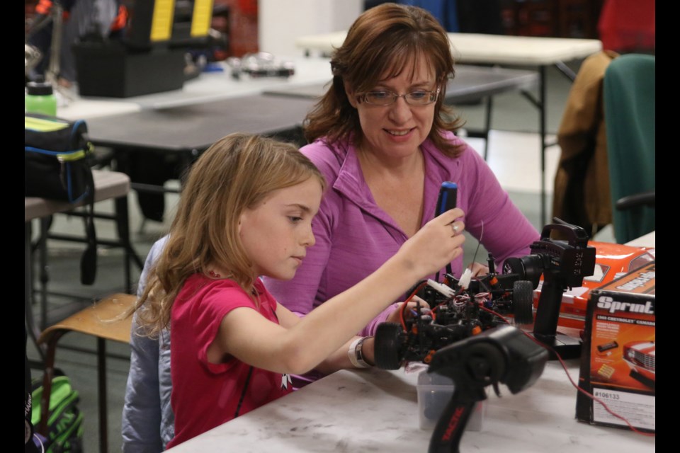 Taiya and Amy Harvey work on their remote controlled car during the Lakehead Radio Control Car Club's annual fundraiser for Toys for Tots last weekend. 