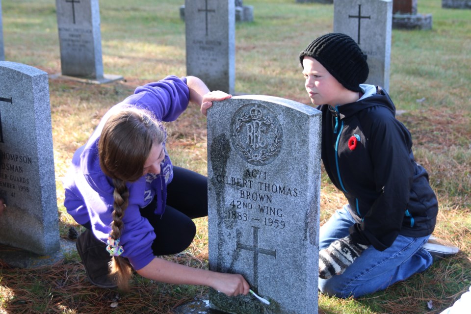 Hope Norton and Brandon Doner, grade 8 students at Woodcrest Public School, work to clean the headstones of men and women who served in the First and Second World Wars at Riverside Cemetery. (Photos by Doug Diaczuk - tbnewswatch.com). 