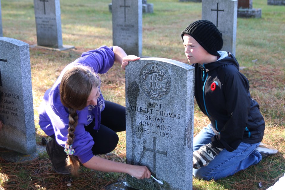 Hope Norton and Brandon Doner, grade 8 students at Woodcrest Public School, work to clean the headstones of men and women who served in the First and Second World Wars at Riverside Cemetery. (Photos by Doug Diaczuk - tbnewswatch.com). 
