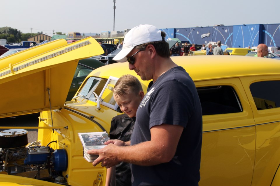 Tanner (left) and Rob Miller looking at pictures of the creation of their father's car. (Michael Charlebois, tbnewswatch.com)