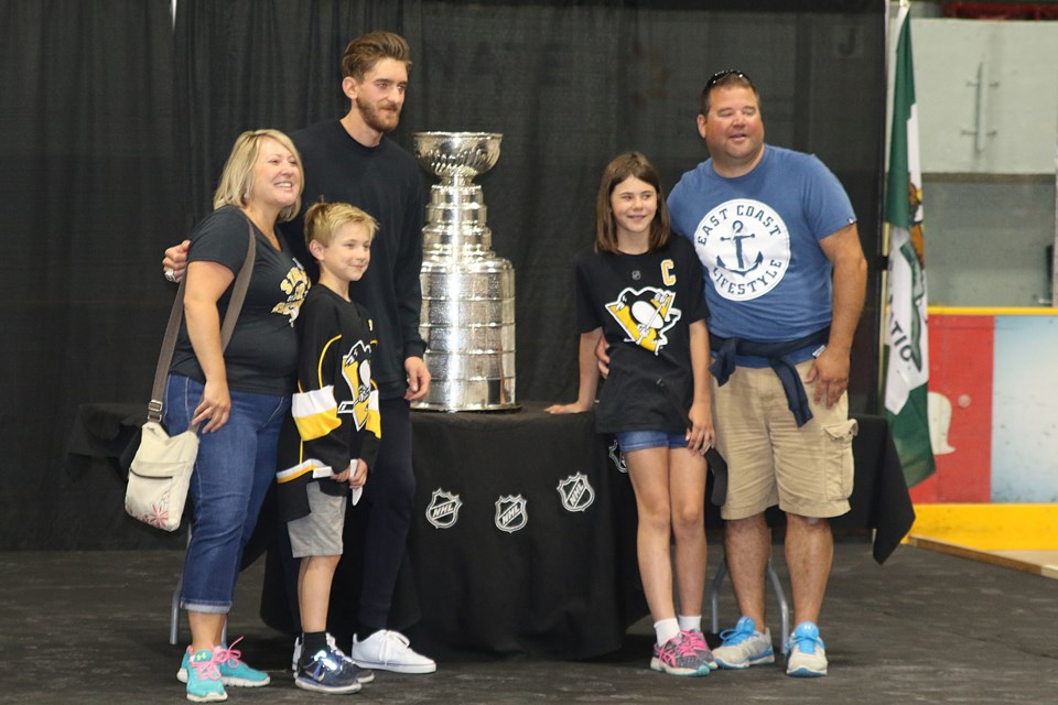 Murray posing with a family full of Pens fans at Fort William Gardens. (Michael Charlebois, tbnewswatch.com)