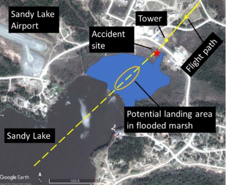 This map shows the accident area at Sandy Lake First Nation with a potential float plane landing zone in a flooded marsh (coloured blue) and its proximity to a communications tower on May26, 2022 (TSB/Google Earth)